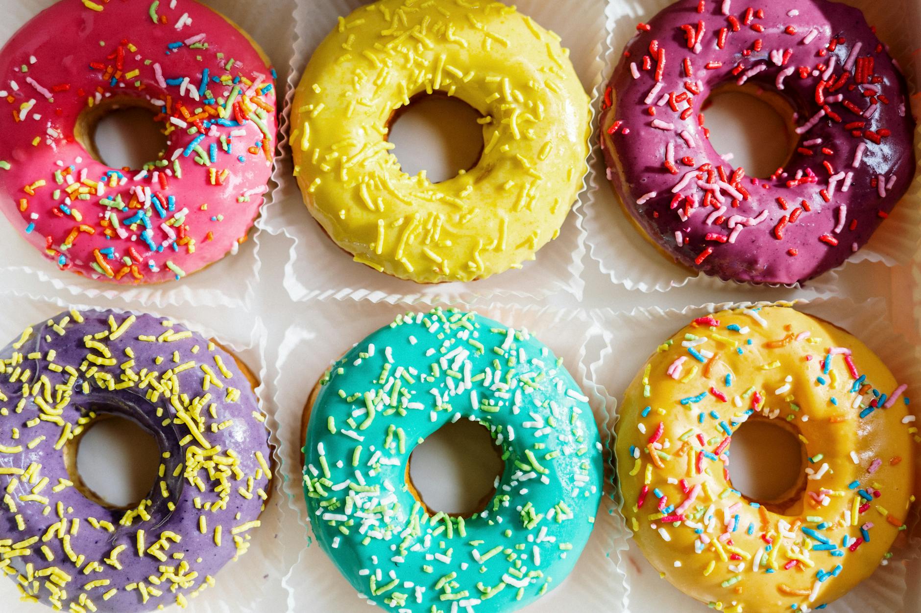 Свежие глазированные пончики с разноцветной посыпкой в пончиковой Сахарная Дырка в Сургуте
